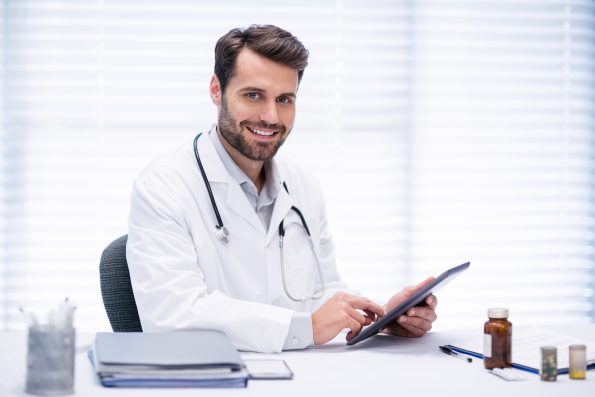 Portrait of male doctor using digital tablet